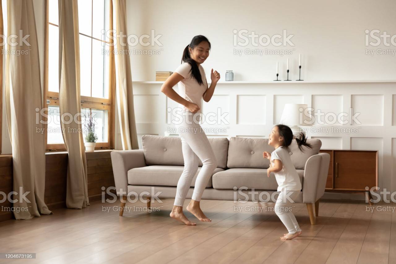 Feliz joven asiático mamá e hija bailando en casa-1204673195-2048x2048.jpg